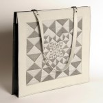 Portfolio de cuir de buffle gris perle et veau noir, jacquard de fil réflectif gris et coton noir, motif Zyx/perspective